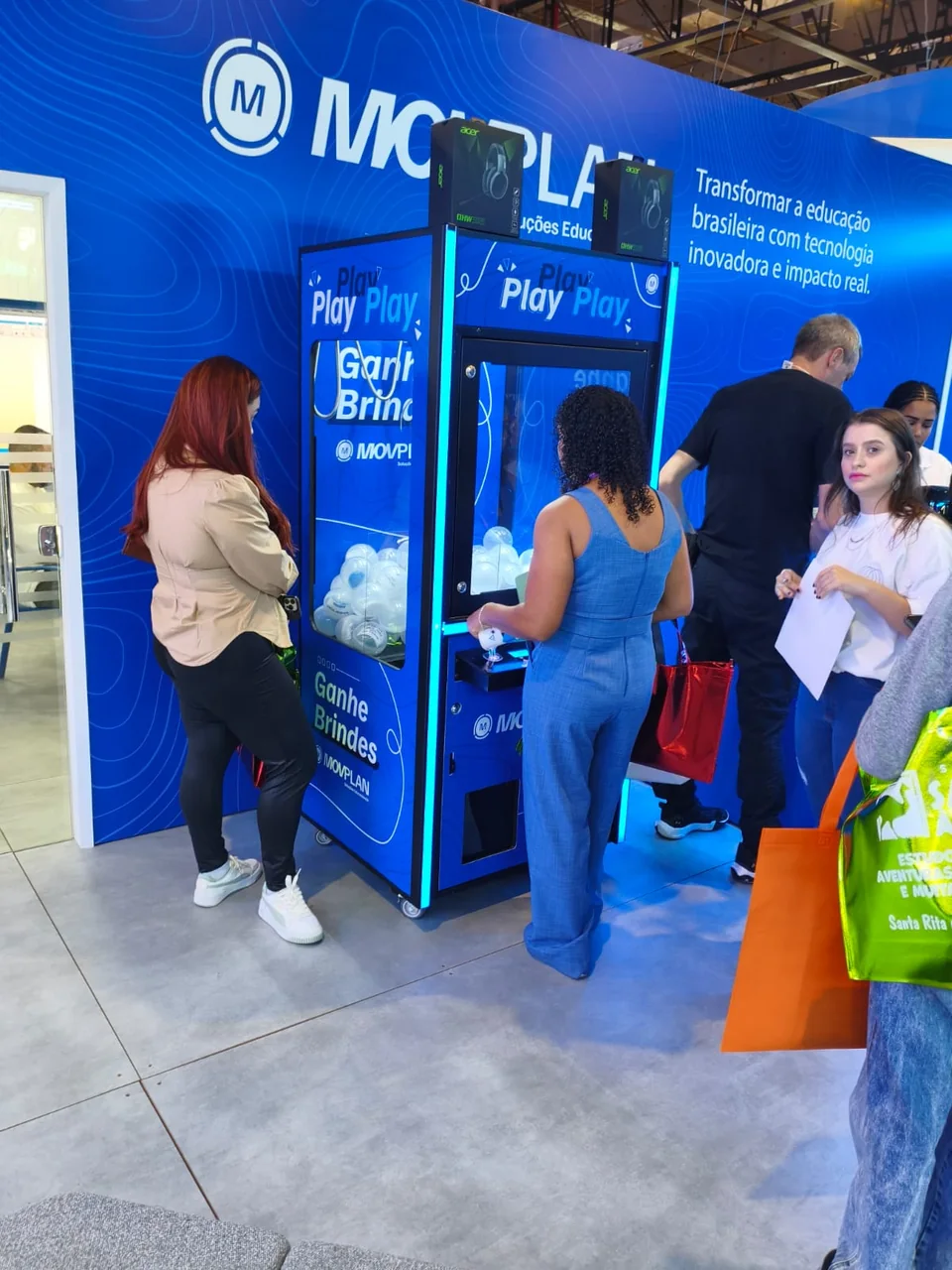 Máquina de Garra personalizada para a Movplan, com participantes no estande